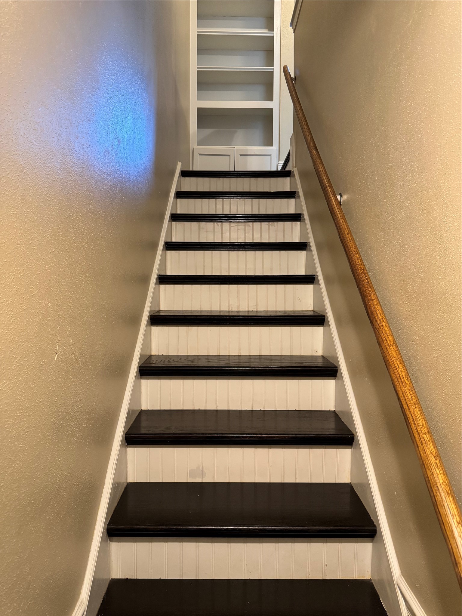 2041 Winrock Boulevard, Unit 157 Houston, TX 77057 - Photo 8 of 25 Solid wood stair treads enhance the home's quality and craftsmanship leading to both private bedrooms with a beautiful built-in display cabinet perfect for decor, collectibles and books.
