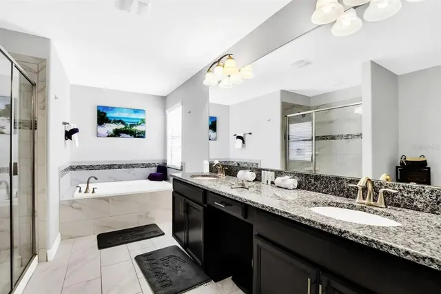 a bathroom with a granite countertop sink mirror and bathtub