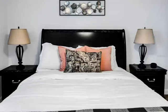 a bedroom with a bed and lamp on table