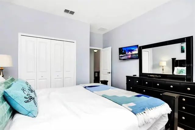 a bedroom with a bed and a large mirror