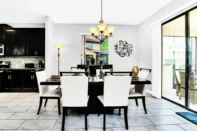 a view of a dining room with furniture a chandelier and wooden floor