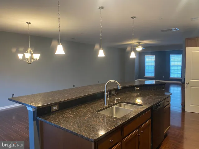 a kitchen with a sink a counter space and a chandelier