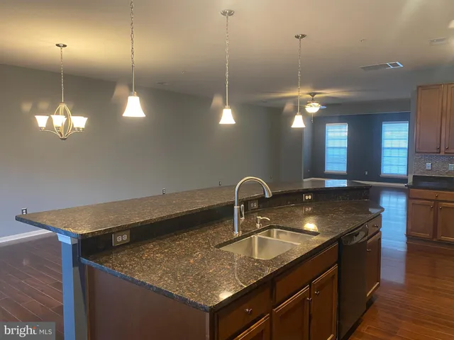 a kitchen with kitchen island a sink stainless steel appliances and chandelier