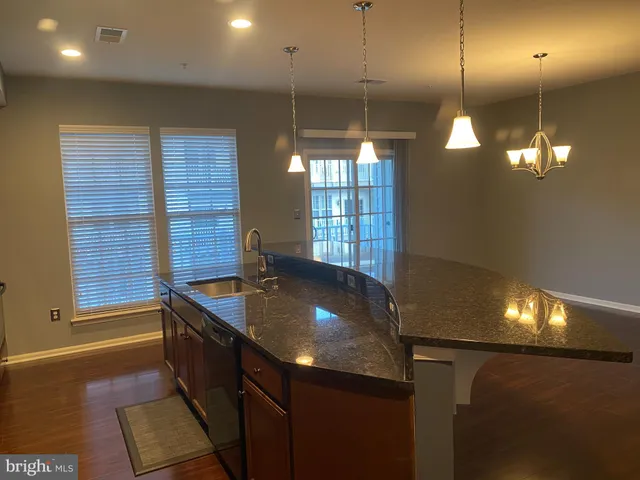 a kitchen with large window and stainless steel appliances