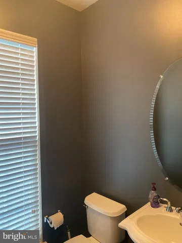 a bathroom with a toilet a sink and a mirror