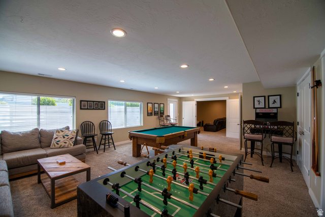 646 East 1400th Street North Mapleton, UT 84664 - Photo 42 of 78 Spacious recreational room featuring recessed lighting, natural light from multiple windows, carpet flooring, a built-in bar area with seating, and a separate adjoining room