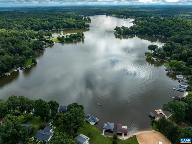 an aerial view of a house with a yard and lake view