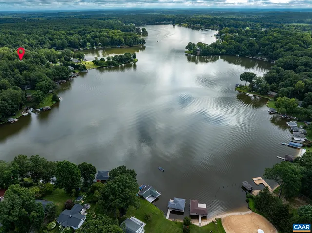 an aerial view of a house with a yard and lake view