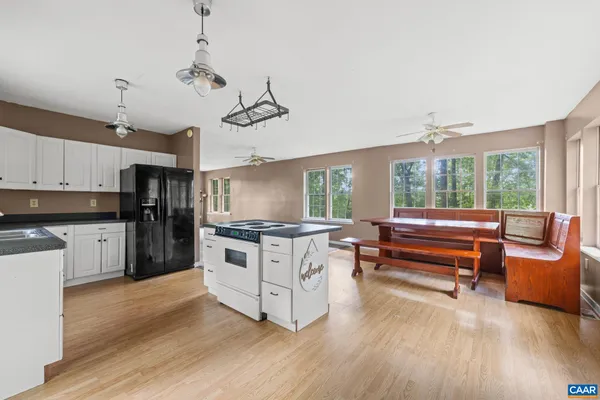 a kitchen with stainless steel appliances granite countertop a stove and white cabinets with wooden floor
