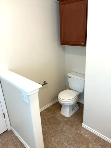 a white toilet sitting next to a white cabinet