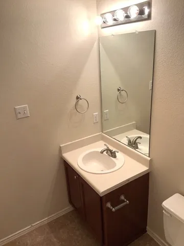 a bathroom with a sink mirror vanity and toilet