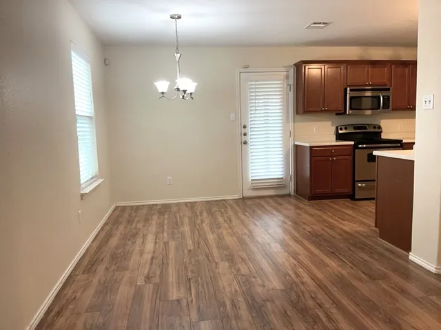 a kitchen with a refrigerator and a stove top oven