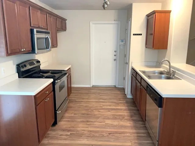 a kitchen with stainless steel appliances granite countertop a sink stove and cabinets