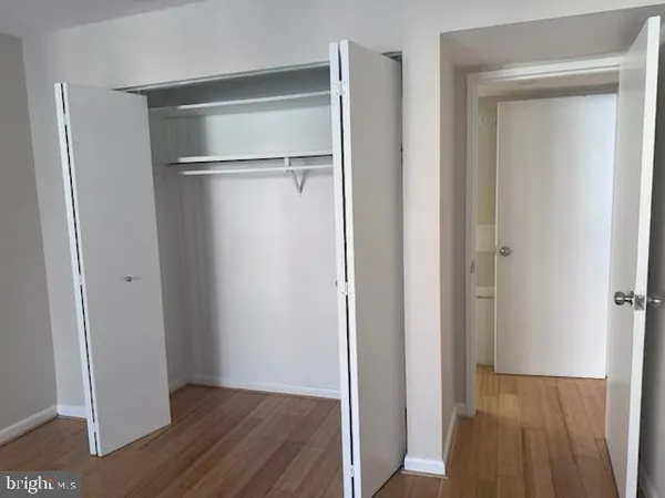 a view of walk in closet with wooden floor