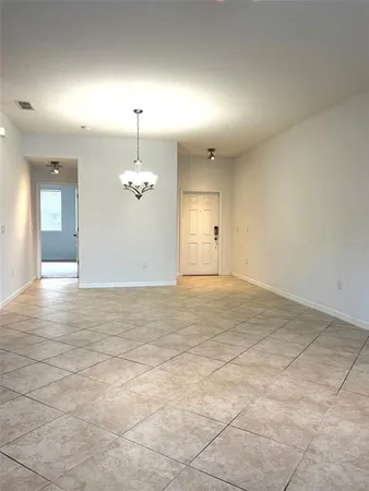an empty room with fan and windows