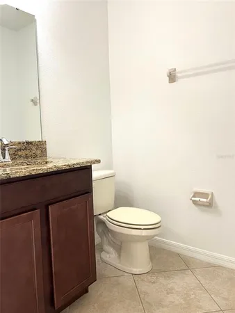 a bathroom with a granite countertop toilet and a sink