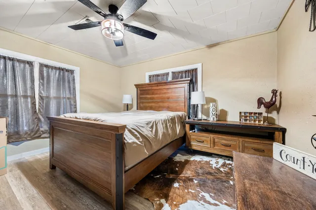 a bed sitting in a spacious bedroom next to a window