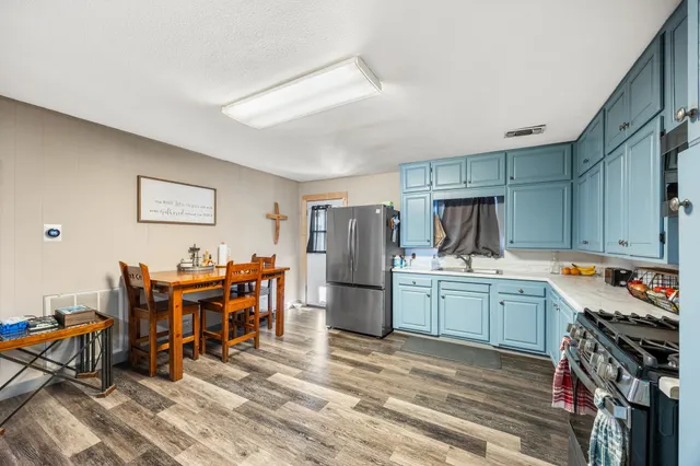 a kitchen that has a lot of cabinets a sink and appliances in it