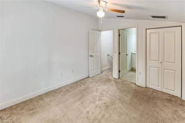 an empty room with windows and fan