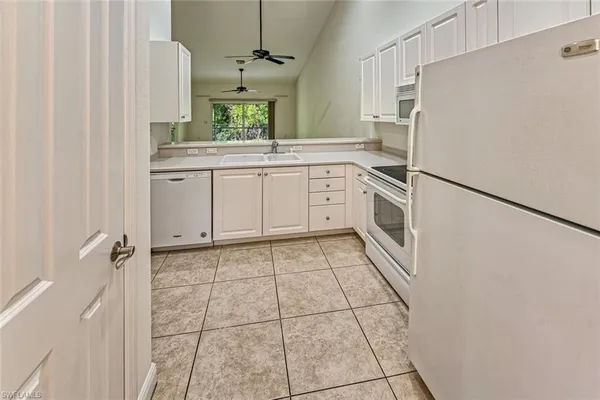 a kitchen with a refrigerator sink and cabinets
