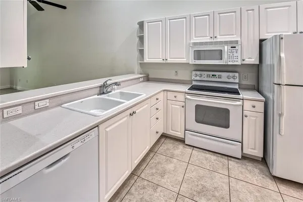 a kitchen with appliances a sink and cabinets