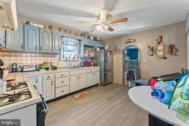 a kitchen that has cabinets a sink and appliances