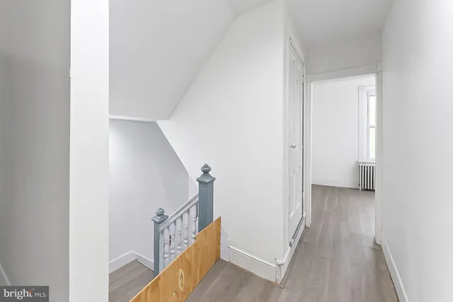 a view of a hallway with wooden floor and entryway
