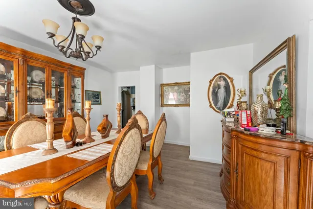 a dining room with furniture a chandelier and wooden floor