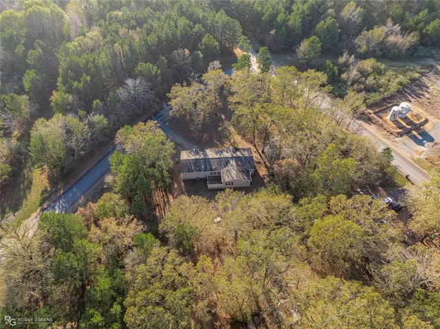 a view of an empty room with a fireplace and chandelier fan