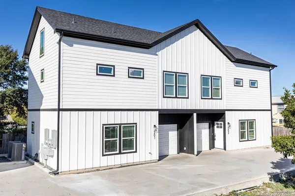 a front view of a house with a tree