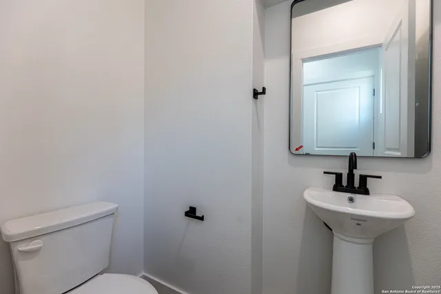 a bathroom with a toilet sink and mirror