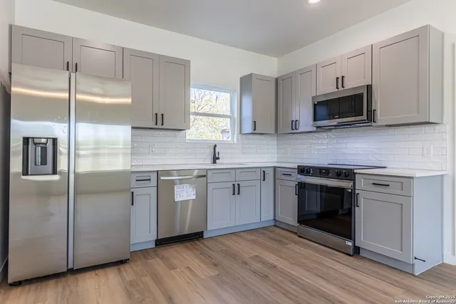 a kitchen with stainless steel appliances granite countertop a stove a sink and a microwave