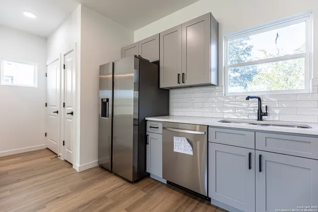 a kitchen with a refrigerator sink and cabinets