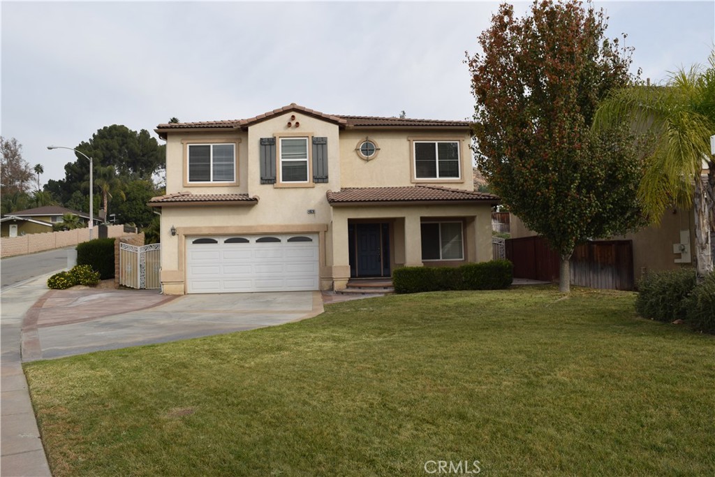 a front view of a house with a garden and yard