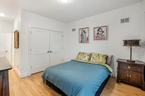 a bedroom with a bed and wooden floor