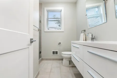a bathroom with a toilet sink and a mirror