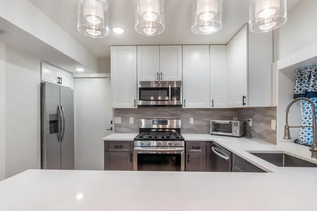 a kitchen with a refrigerator and a stove top oven