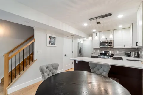 a large white kitchen with lots of counter space a sink a refrigerator and cabinets