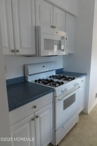 a white stove top oven sitting inside of a kitchen