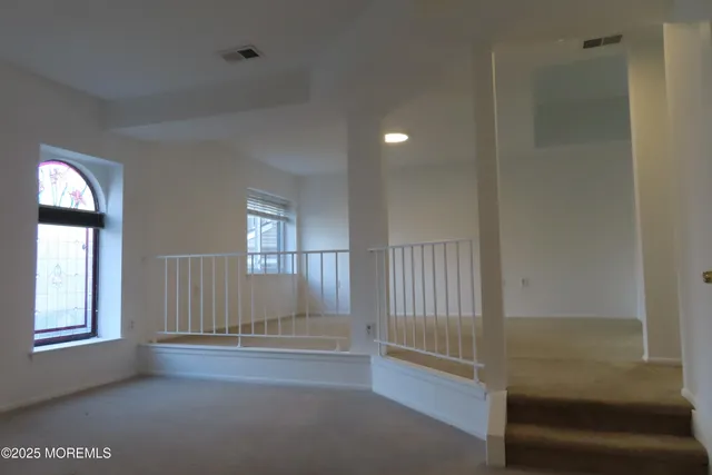 an empty room with windows and closet