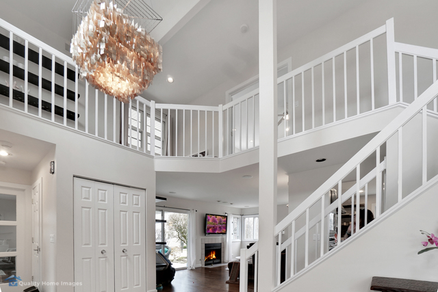 603 Raintree Road Buffalo Grove, IL 60089 - Photo 2 of 20 a view of staircase with lots of frames on wall and a chandelier