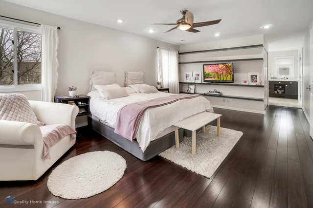 603 Raintree Road Buffalo Grove, IL 60089 - Photo 11 of 20 a spacious bedroom with a bed a couch and a flat screen tv