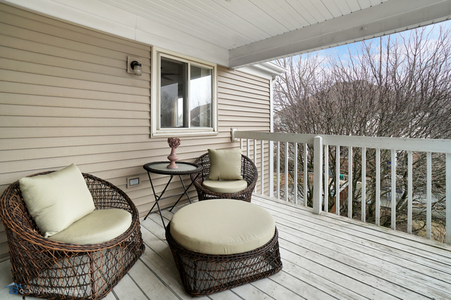 603 Raintree Road Buffalo Grove, IL 60089 - Photo 13 of 20 a patio with wooden floor a yard a glass table and chairs