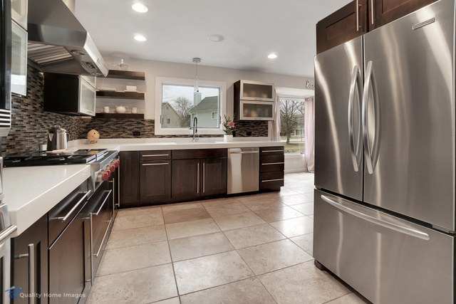 603 Raintree Road Buffalo Grove, IL 60089 - Photo 3 of 20 a kitchen with stainless steel appliances granite countertop a refrigerator a sink a stove top oven and cabinets