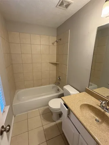 a bathroom with a granite countertop sink a toilet and bathtub