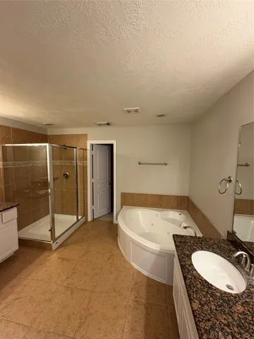 a bathroom with a tub sink and mirror