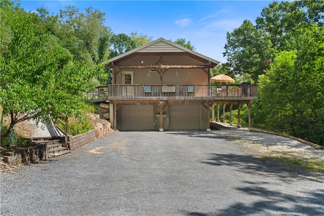 7353 Farrier Road Orefield, PA 18069 - Photo 8 of 74 An expansive elevated deck sits above a two-car garage framed by mature trees.