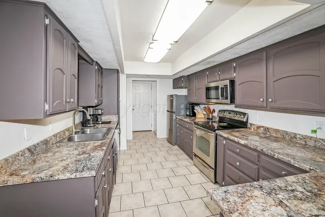 a kitchen with stainless steel appliances granite countertop a stove sink and cabinets