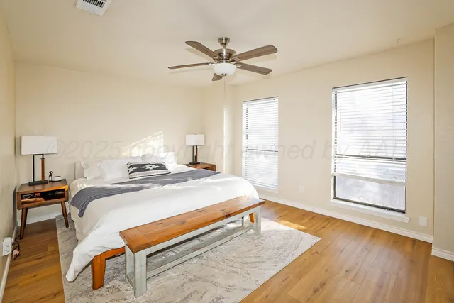 a bedroom with a bed and wooden floor