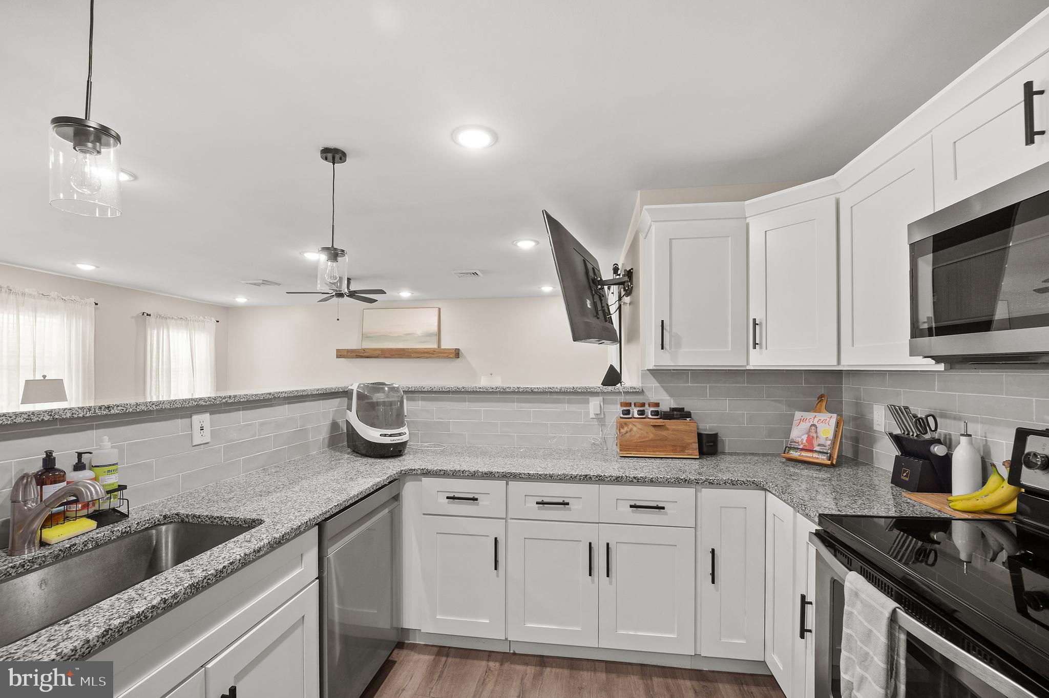 837 Fairfield Road Fairless Hills, PA 19030 - Photo 7 of 31 a kitchen with a sink dishwasher and white cabinets with wooden floor